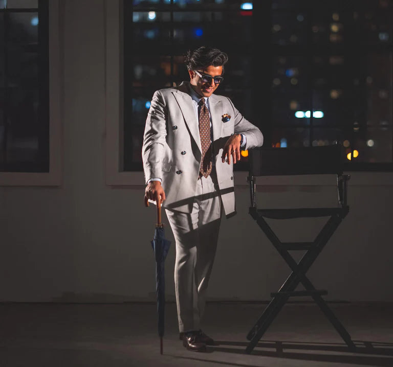 man in grey suit by chair