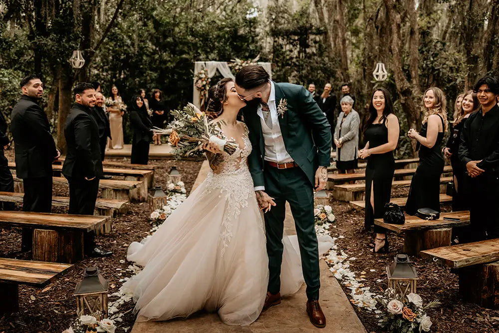 groom in dark green wedding suit with bride