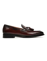 Brown loafer with a tassel on a white background