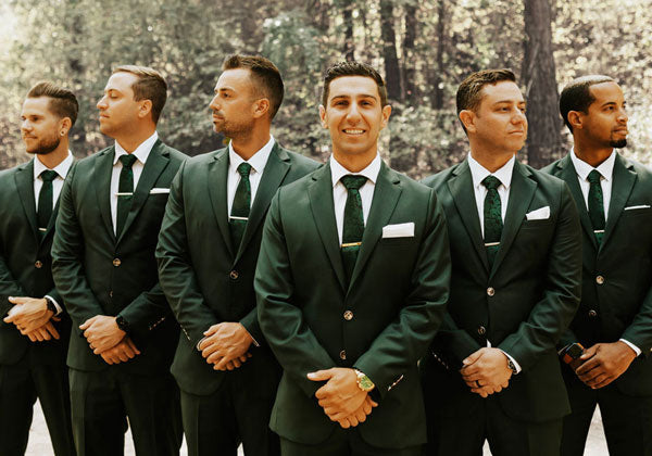 a groom and five groomsmen in dark green suits