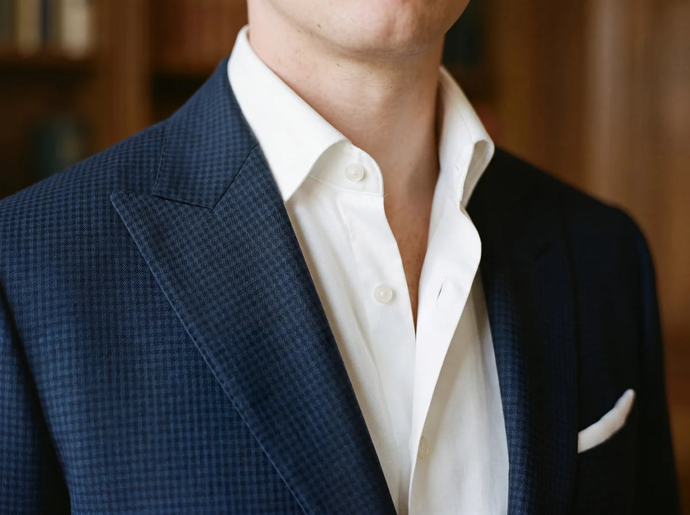 Close-up of an open shirt collar worn under a suit jacket with no tie