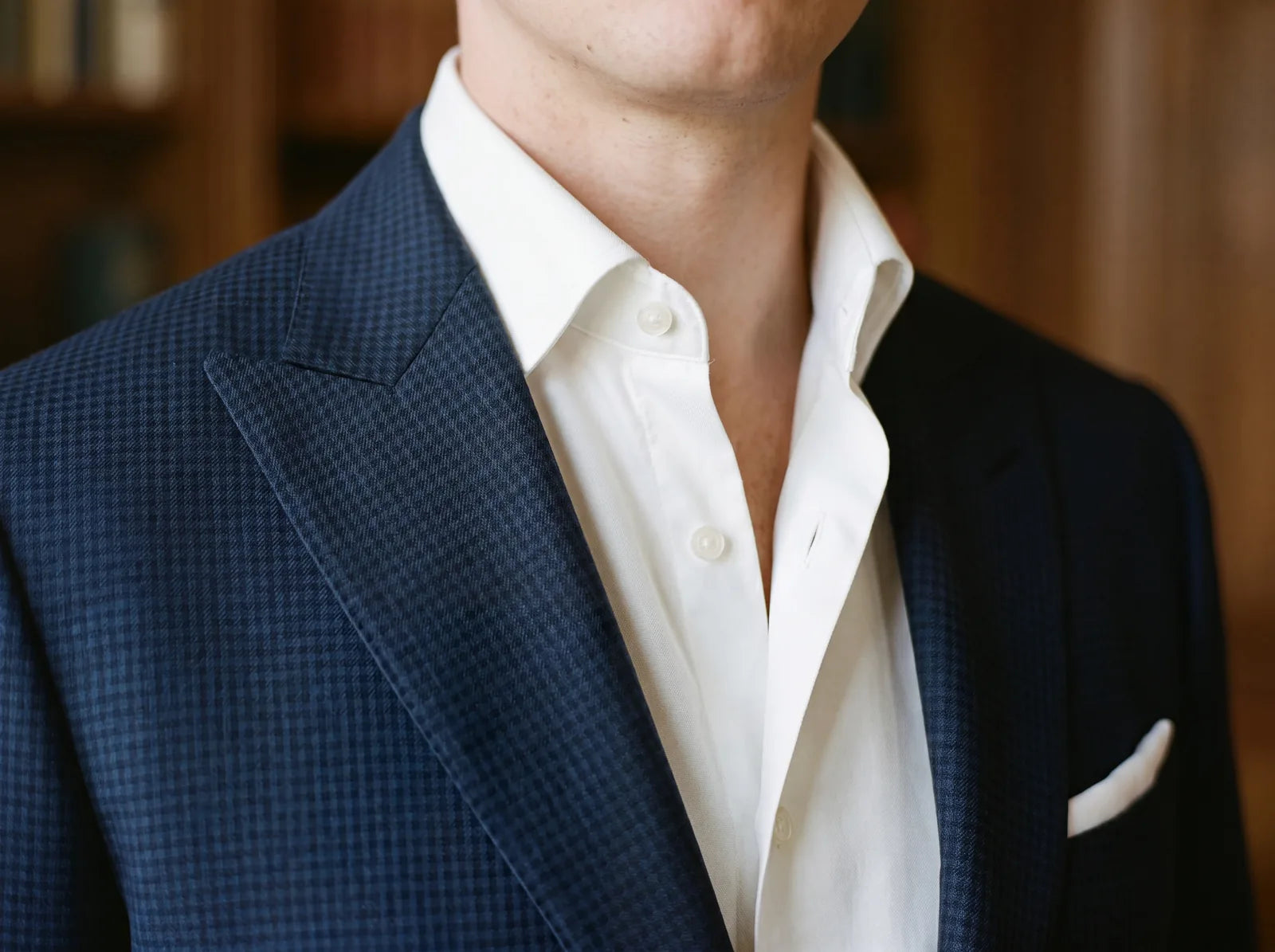 Close-up of an open shirt collar worn under a suit jacket with no tie