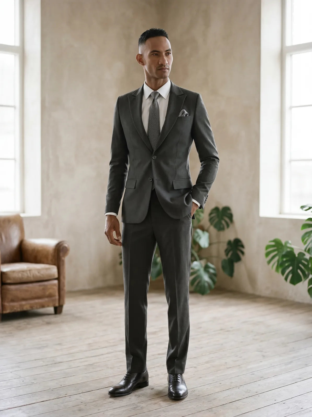 A man wearing a versatile charcoal first suit with a white shirt