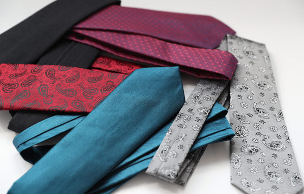 a small pile of folded ties in a variety of colors
