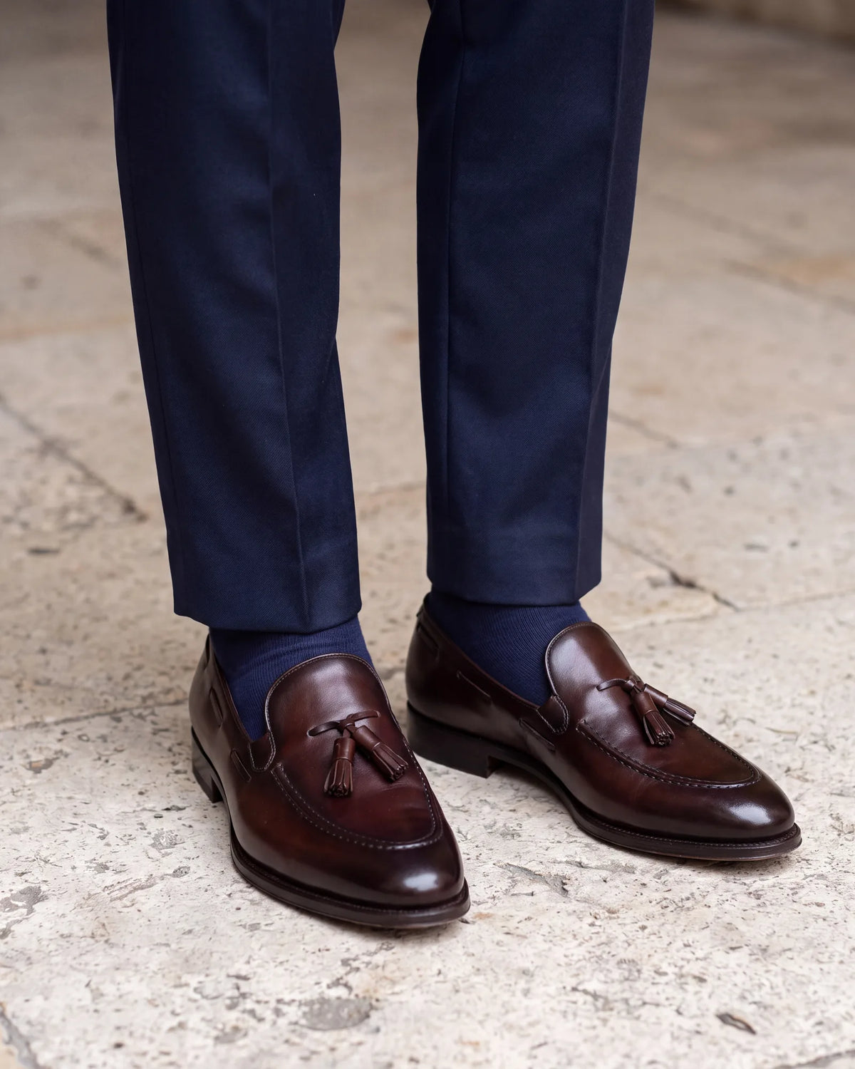 Pick socks by the trouser color, not the shoe. Navy socks under navy trousers keep the leg unbroken when you sit.