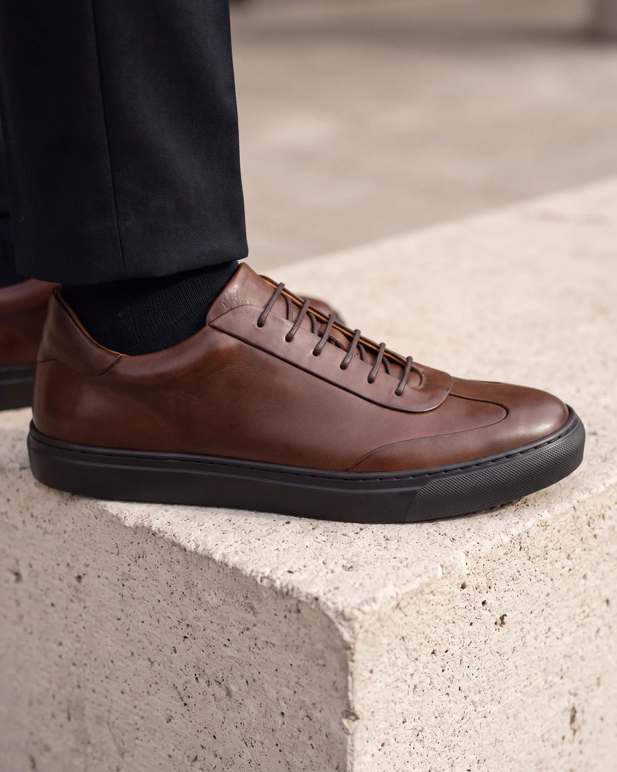 Before you wear sneakers to work, check the upper, the sole and the logo. Smooth leather, a thin one-color sole and no branding pass.