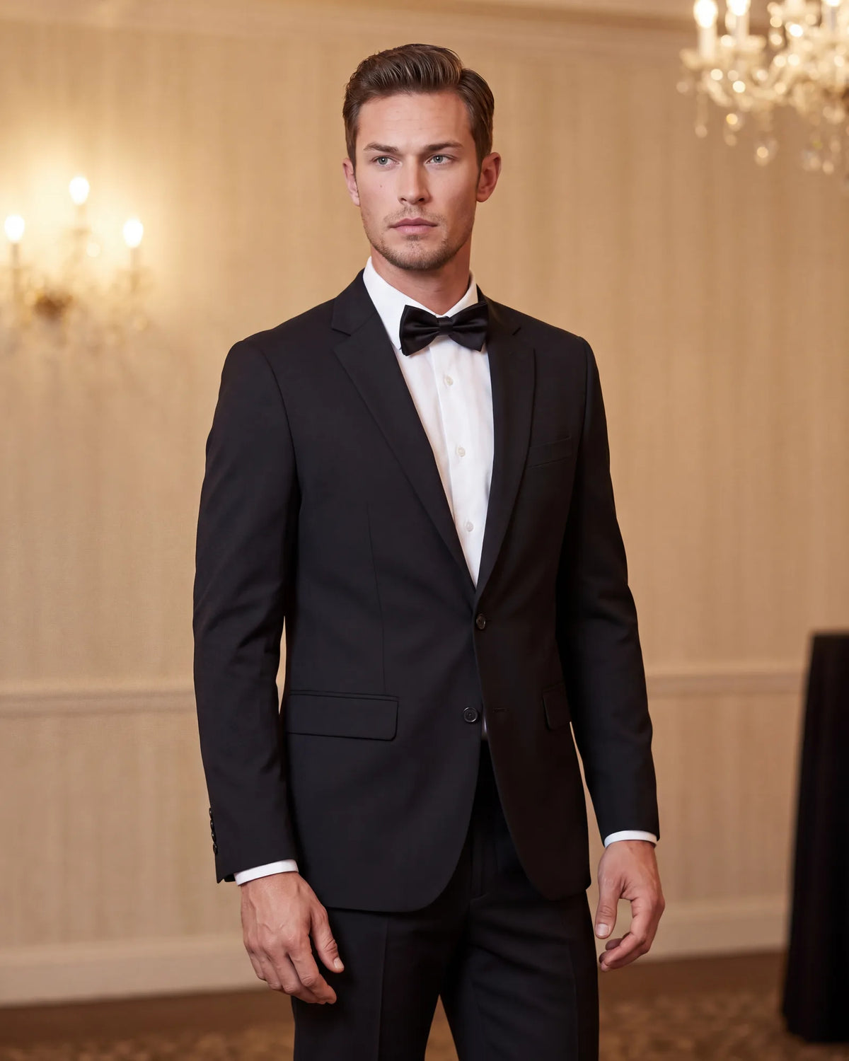 Check the lapels before black tie. A black suit with a bow tie keeps plain lapels in its own cloth, so it still reads as a suit.