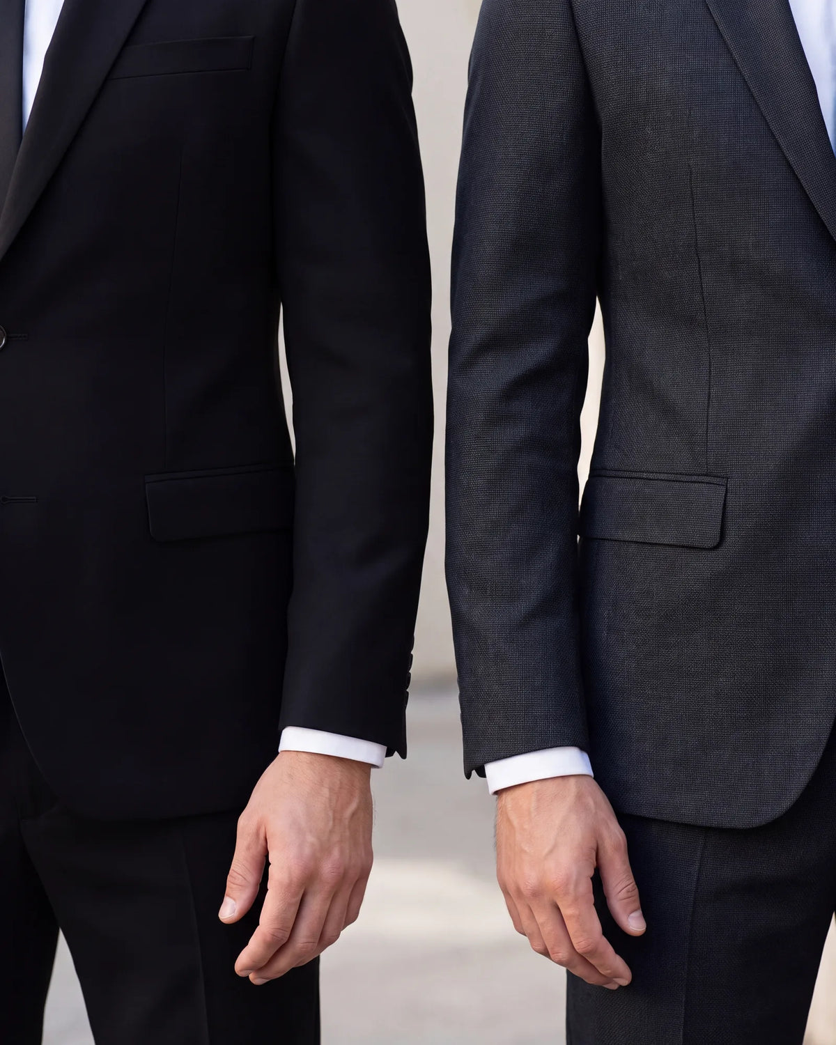 Look at the cloth in daylight. Charcoal shows its weave, while black stays flat with no visible texture.