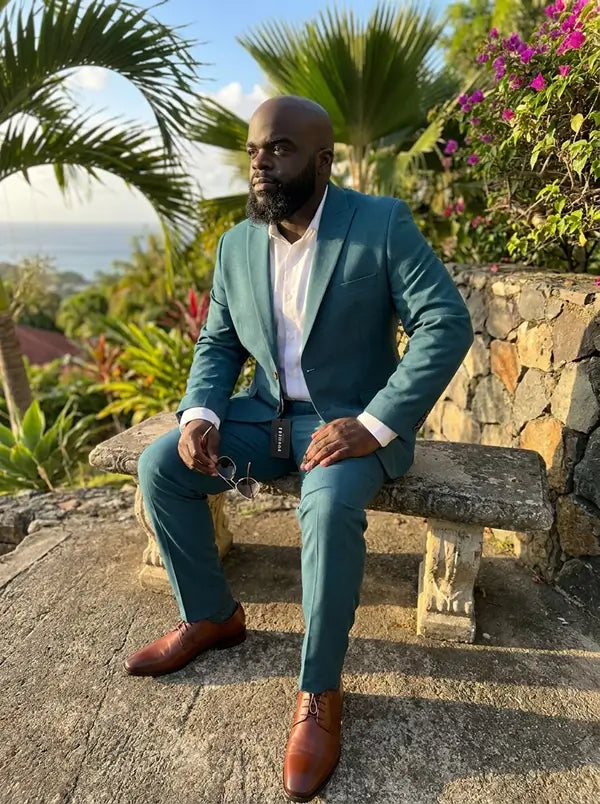 man sitting down in teal suit