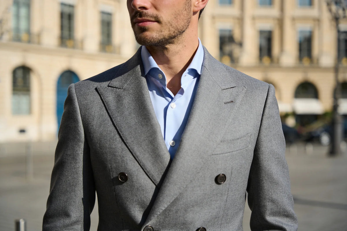 Close view of a grey double-breasted suit showing the peak lapels and two rows of buttons