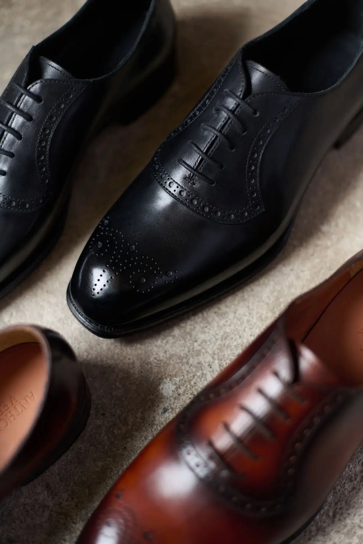 Black and brown dress shoes on a textured surface