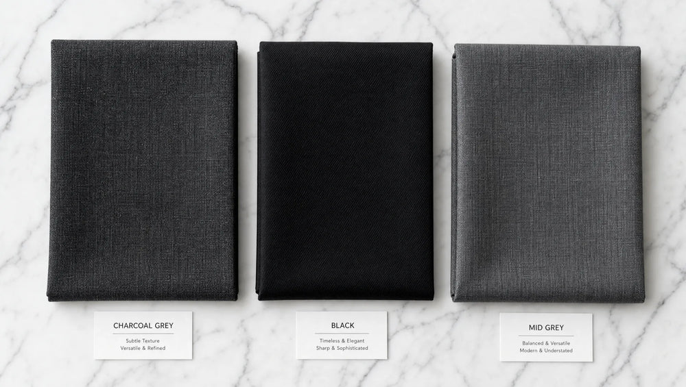 Charcoal, black, and mid-grey fabrics compared — charcoal sits between the formality of black and the casualness of lighter grey, winning in nearly every professional context