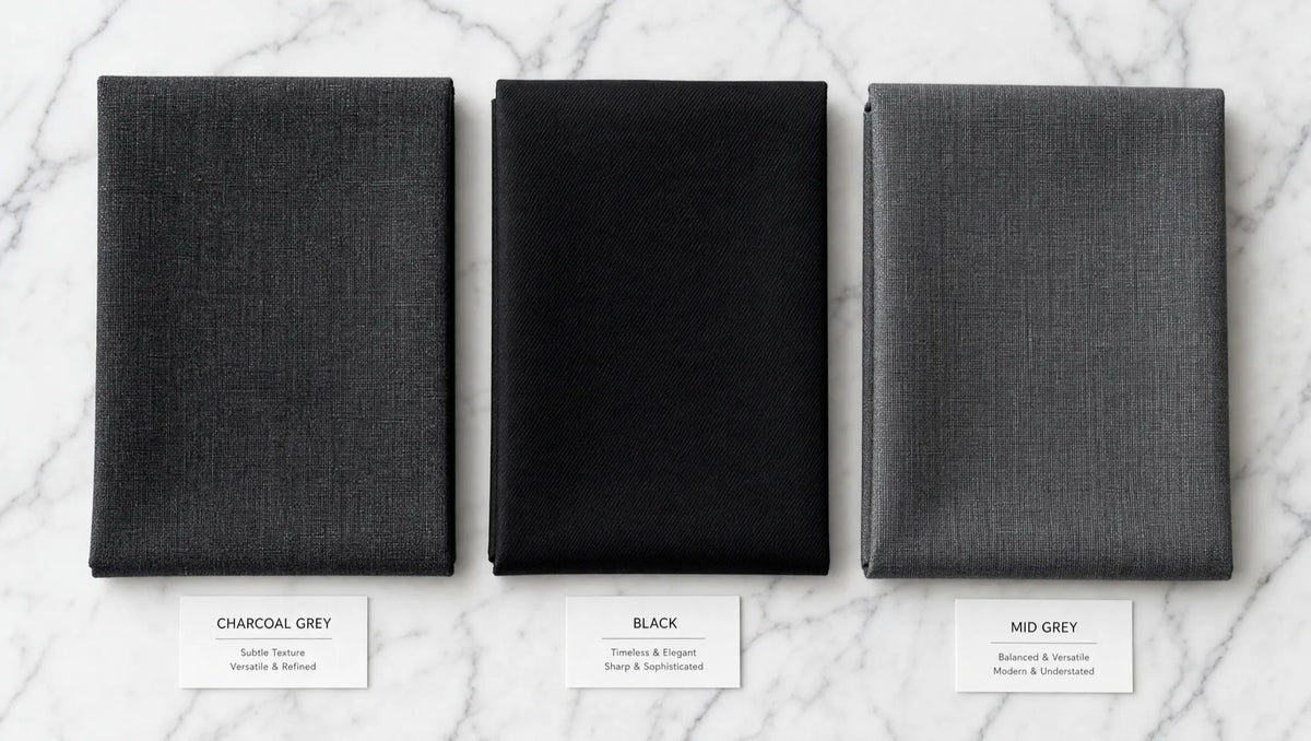 Charcoal, black, and mid-grey fabrics compared — charcoal sits between the formality of black and the casualness of lighter grey, winning in nearly every professional context
