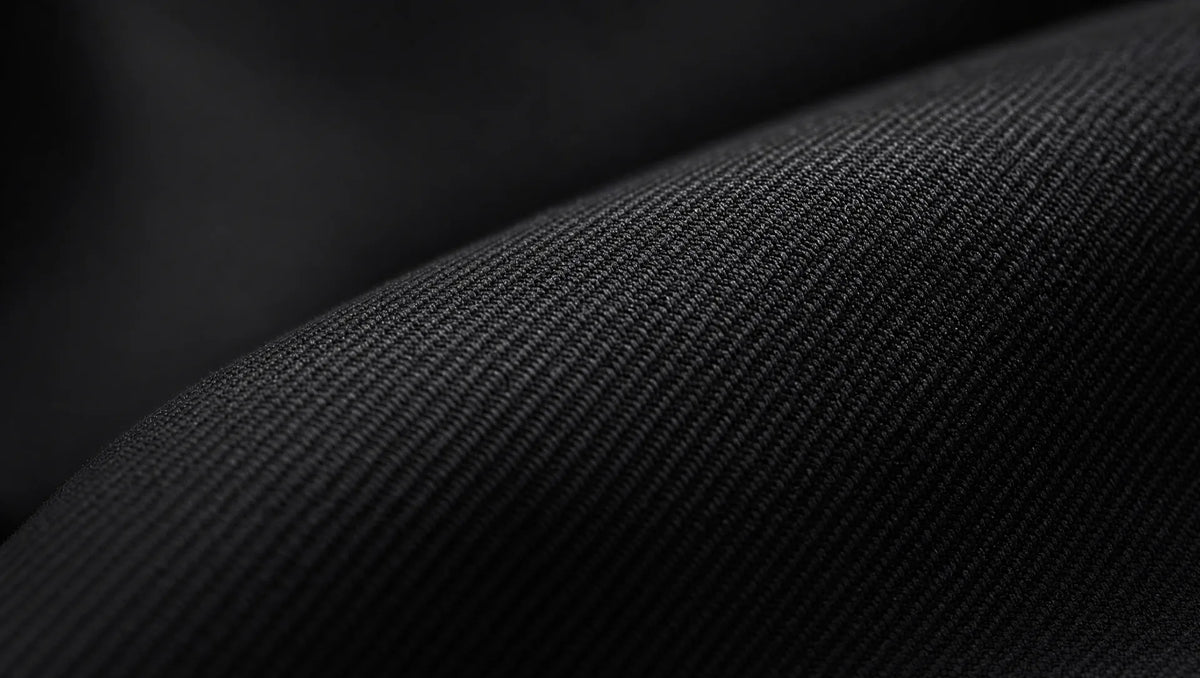 Flat worsted wool in jet black — the smooth, dense weave catches light as a subtle sheen rather than texture, which is why fabric quality matters more in black than any other suit color