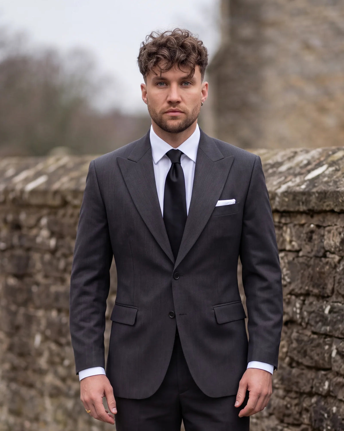 A charcoal suit with a white shirt and black tie is widely worn at funerals. Its quiet color keeps attention on the family.