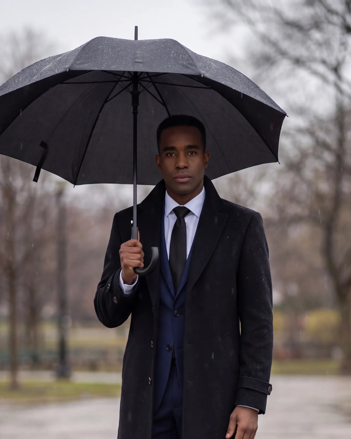 In rain or cold, add a dark overcoat and a black umbrella, so the whole outfit stays dark.