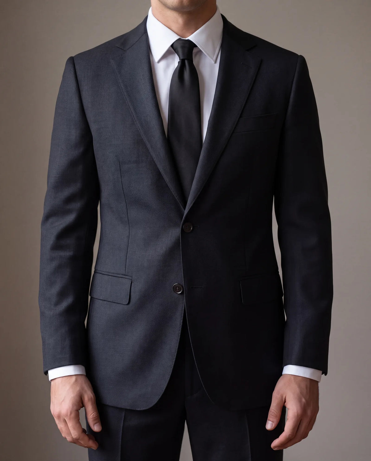 This tie is solid black, worn with a white shirt. Charcoal, navy or a quiet, low-contrast pattern also works.