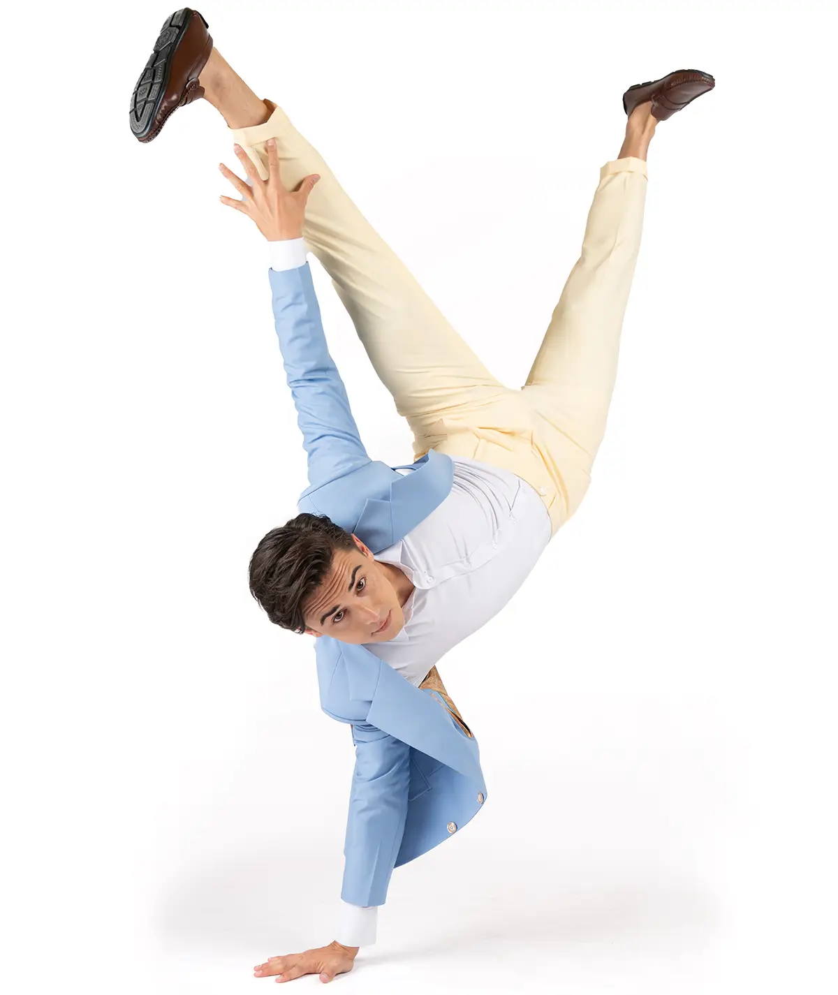 model in blue jacket and yellow pants doing a handstand