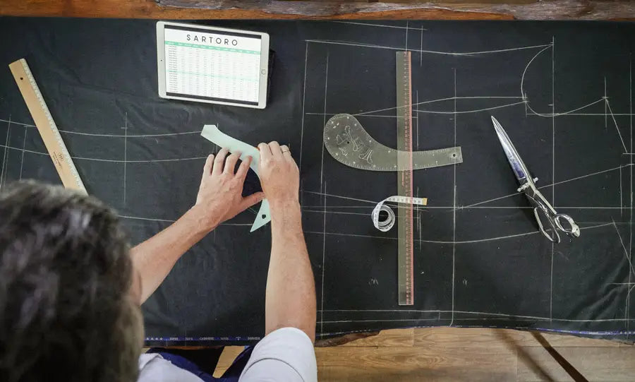 a man drawing suit patterns on fabric