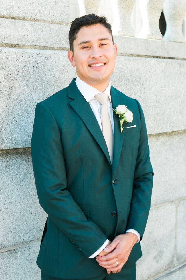 groom in green suit smiling