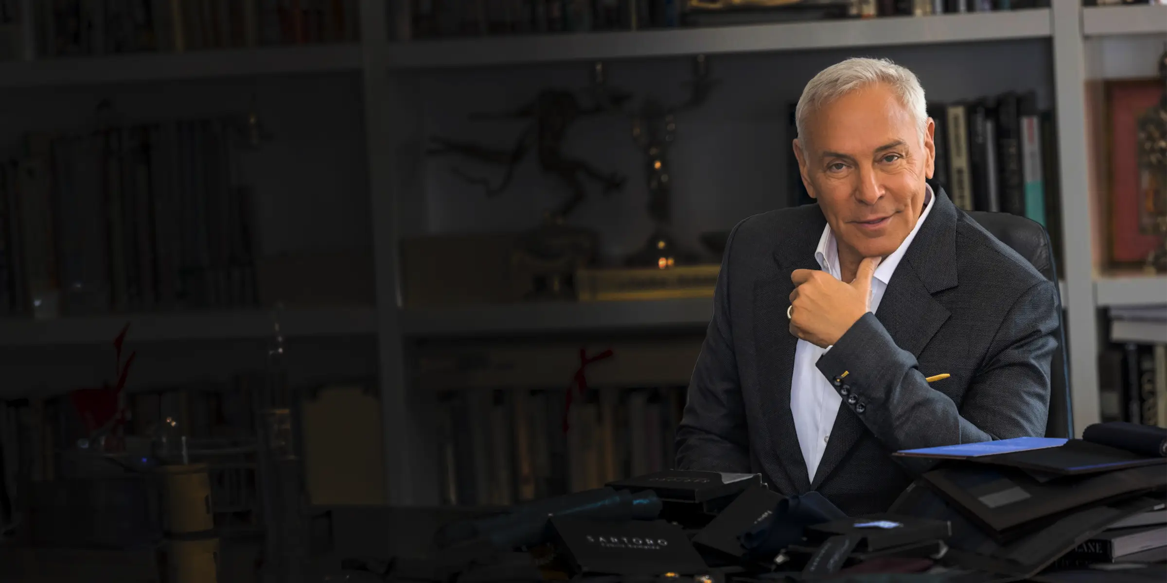 Neil Lane sitting at desk with fabric samples