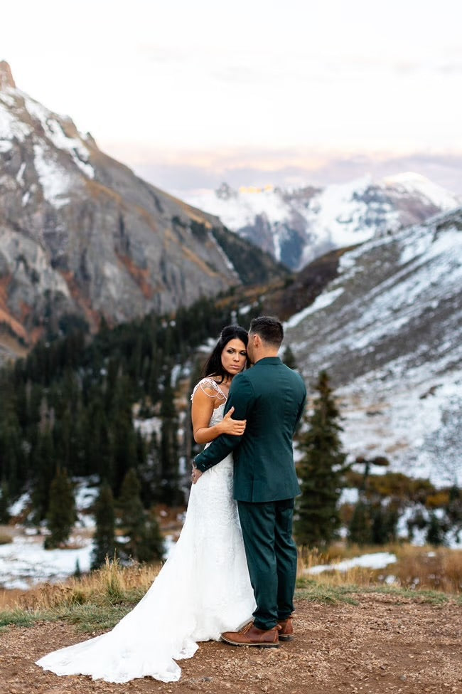 bride and groom embracing under the mountains