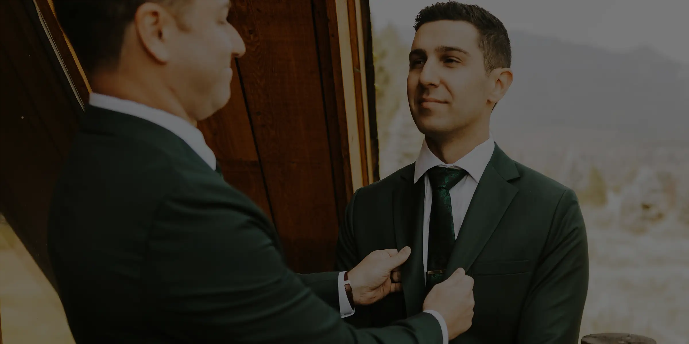 two guys adjusting their green suits