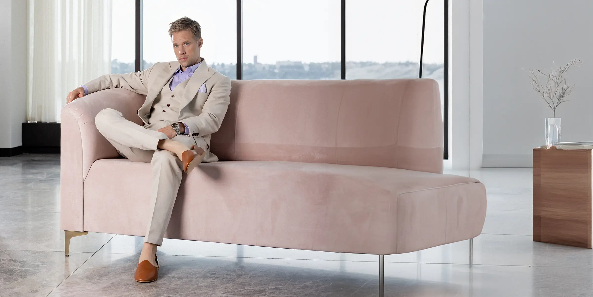 man on couch in tan suit