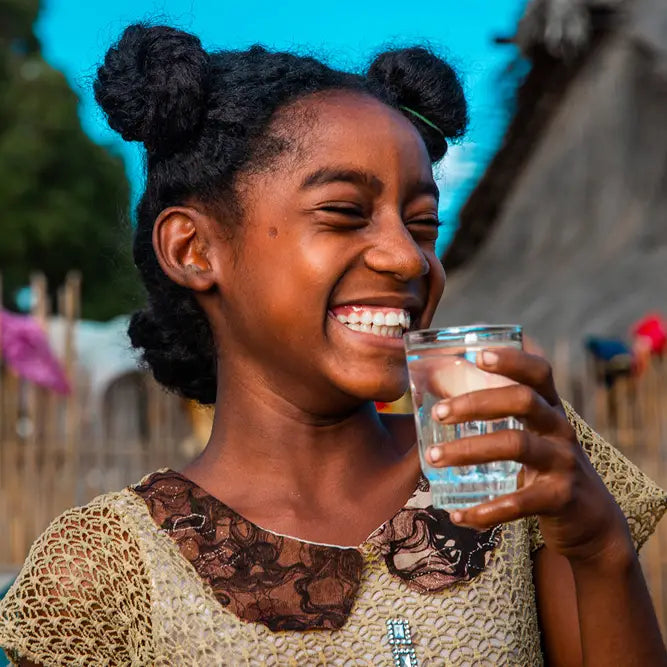 black girl smiling while drinking water