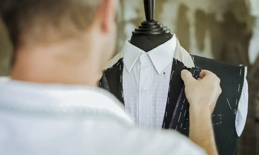 a man examining an unfinished suit jacket