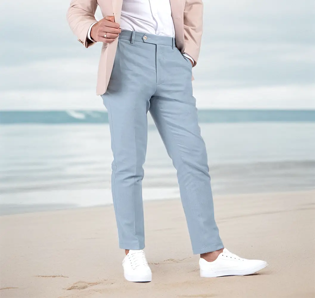 model in blue pants standing on beach