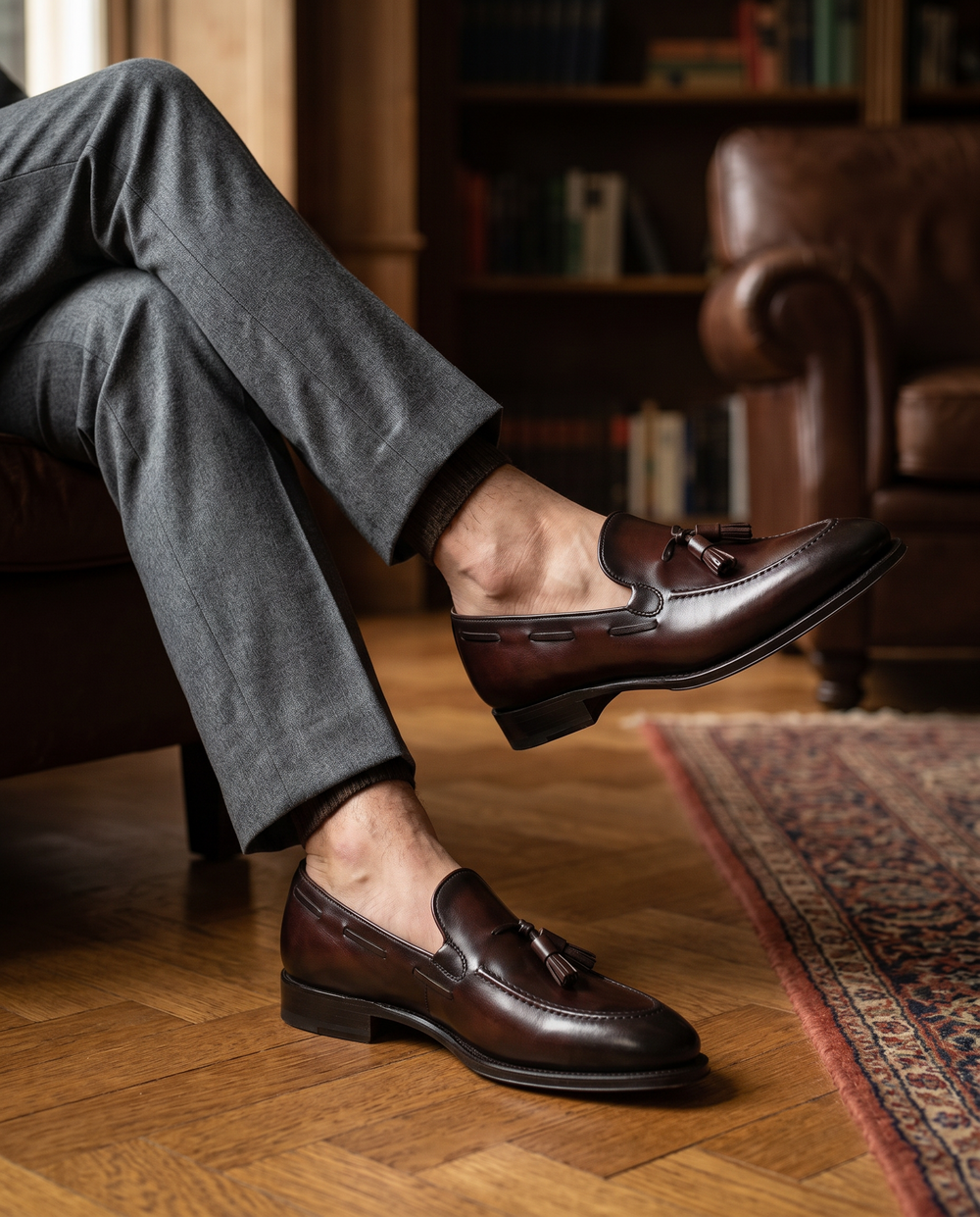 Dark brown tassel loafer worn sockless, editorial shot in a refined interior