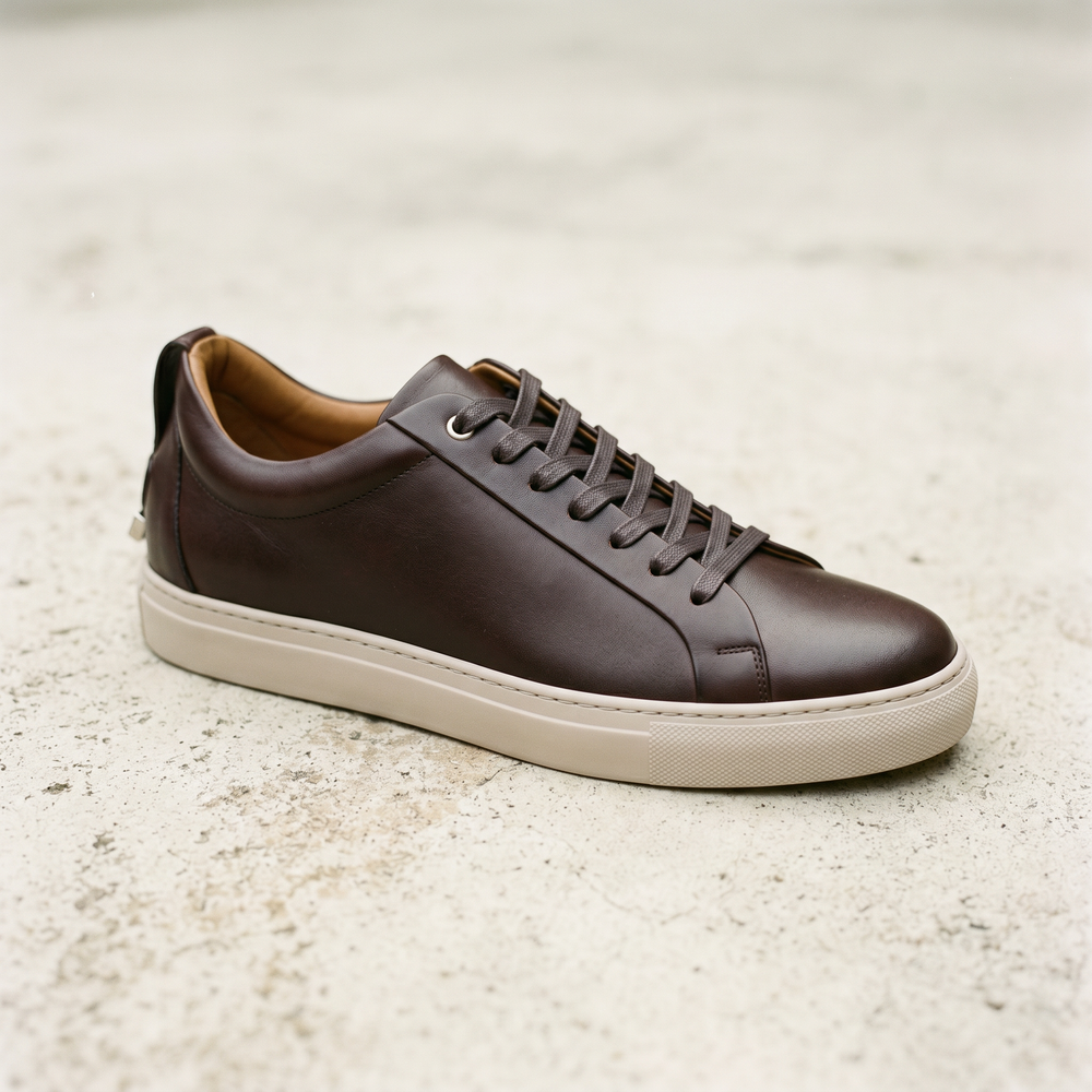 Low-profile espresso leather sneaker with a thin single-color sole and minimal branding