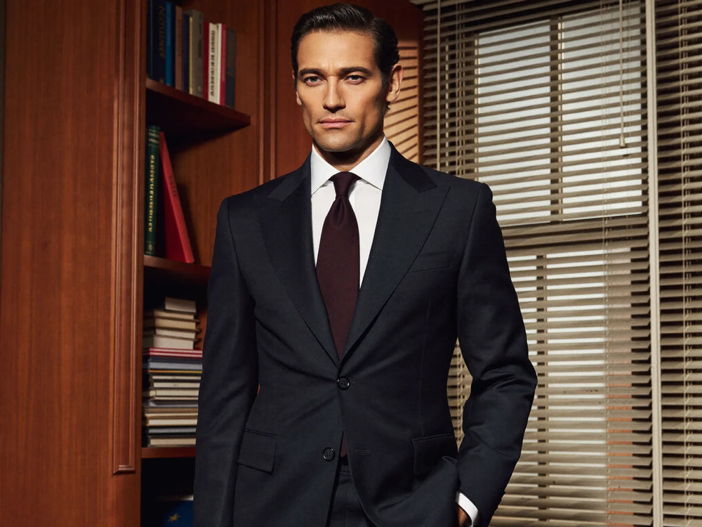 Man in a deep-navy peak-lapel power suit with a burgundy silk tie, Harvey Specter power-suit style