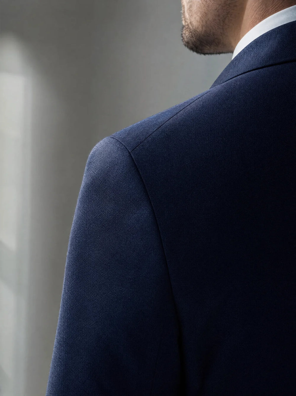 Close view of a suit jacket shoulder seam and natural shoulder construction