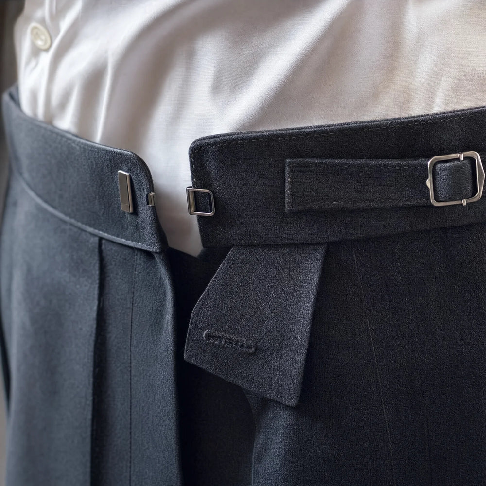 Close view of a trouser waistband with side adjusters