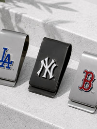 Three metallic money clip money clipers featuring the Los Angeles Dodgers, New York Yankees, and Boston Red Sox logos, displayed on a light gray stone surface.