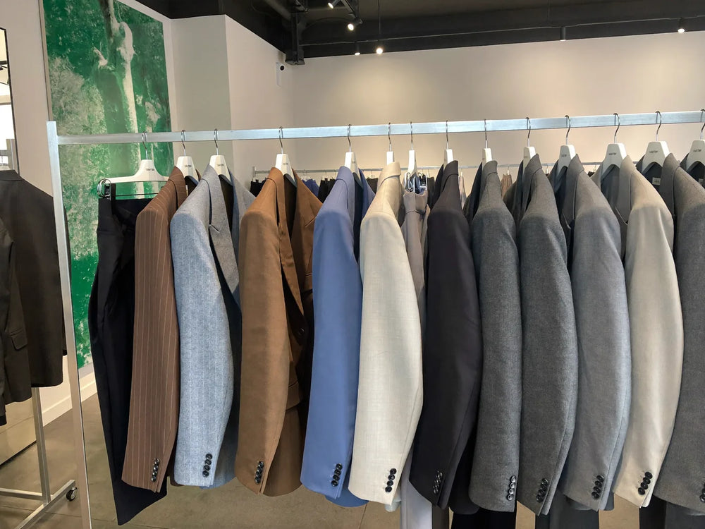 A rack of ready-made off-the-rack suits hanging in a menswear store