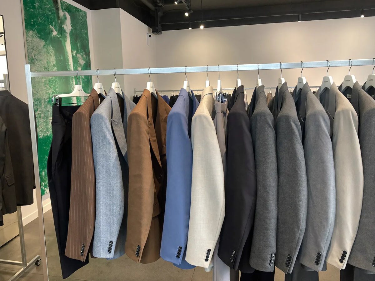 A rack of ready-made off-the-rack suits hanging in a menswear store