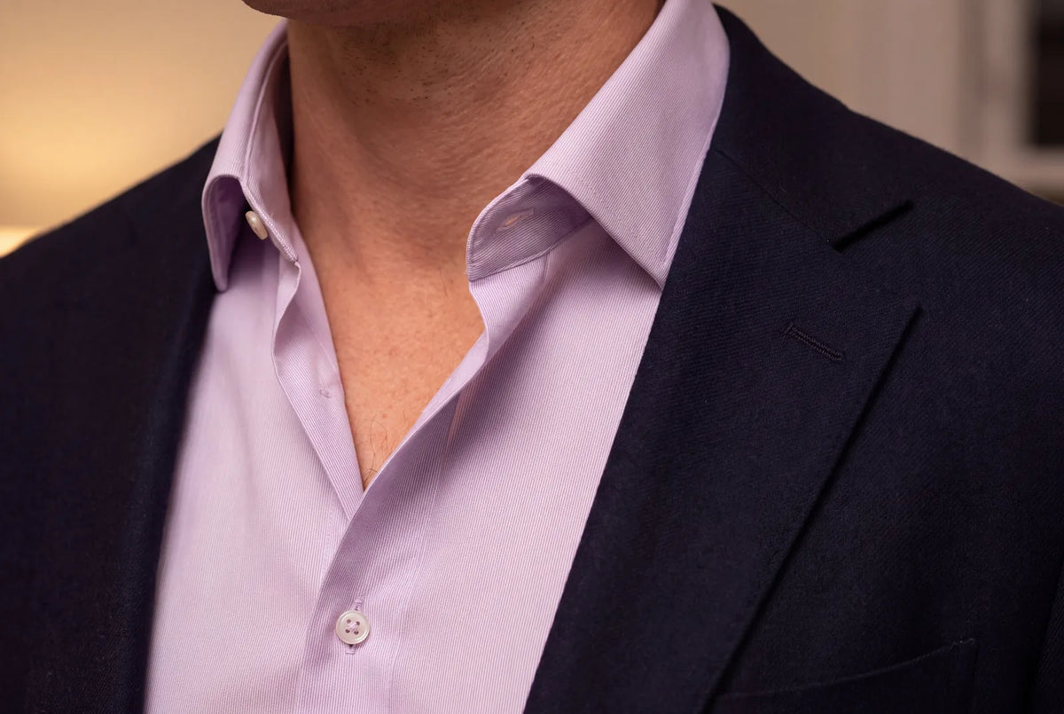Colored dress shirt worn under an open dark jacket, collar detail