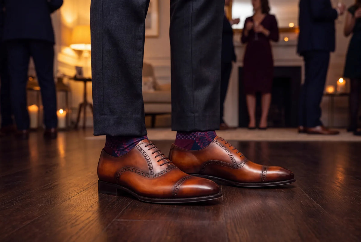 Tan leather brogues and patterned dress socks worn at an evening party
