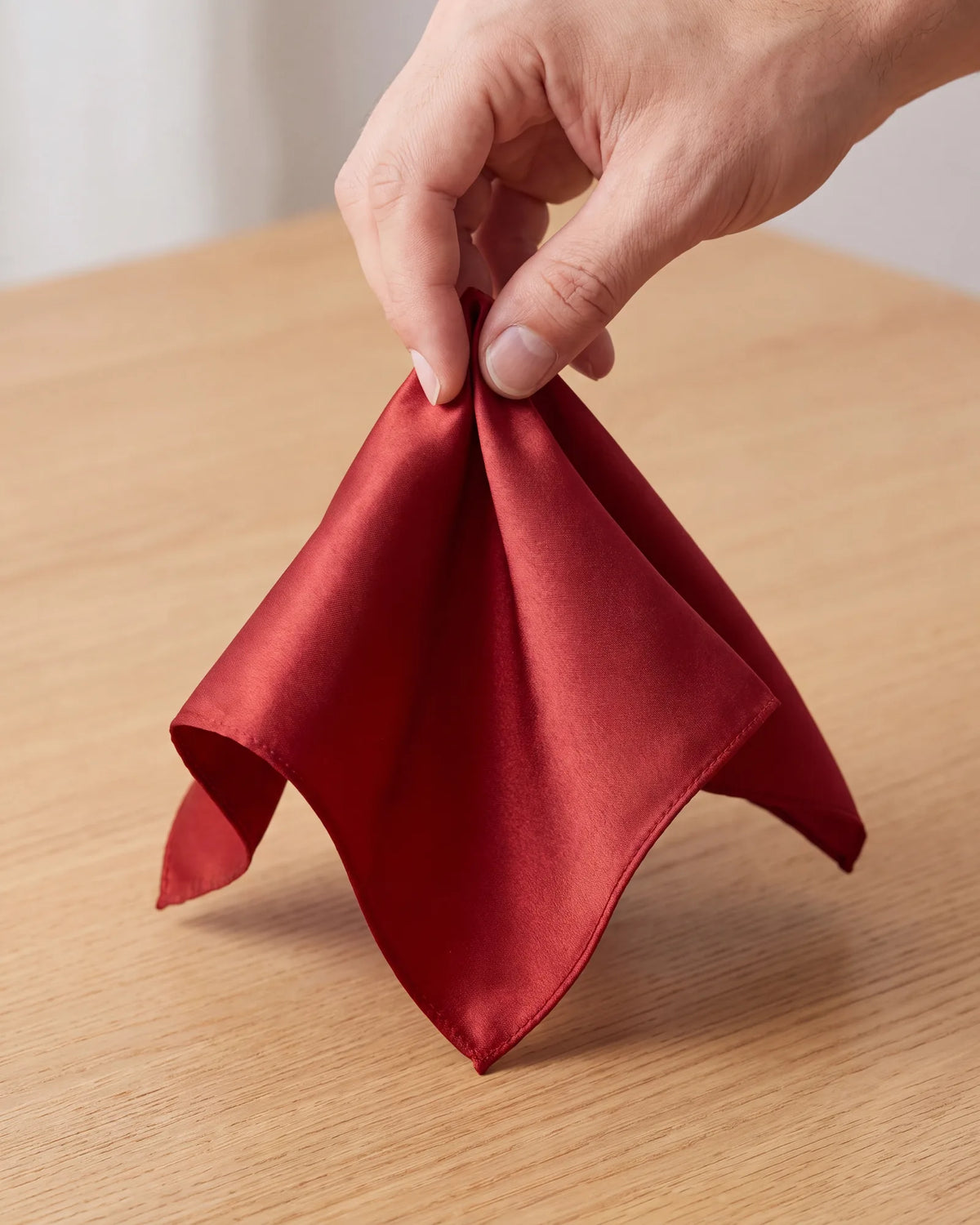 Start a puff by lifting the square at its center. Next, gather the hanging folds loosely in your other hand, just under that point.