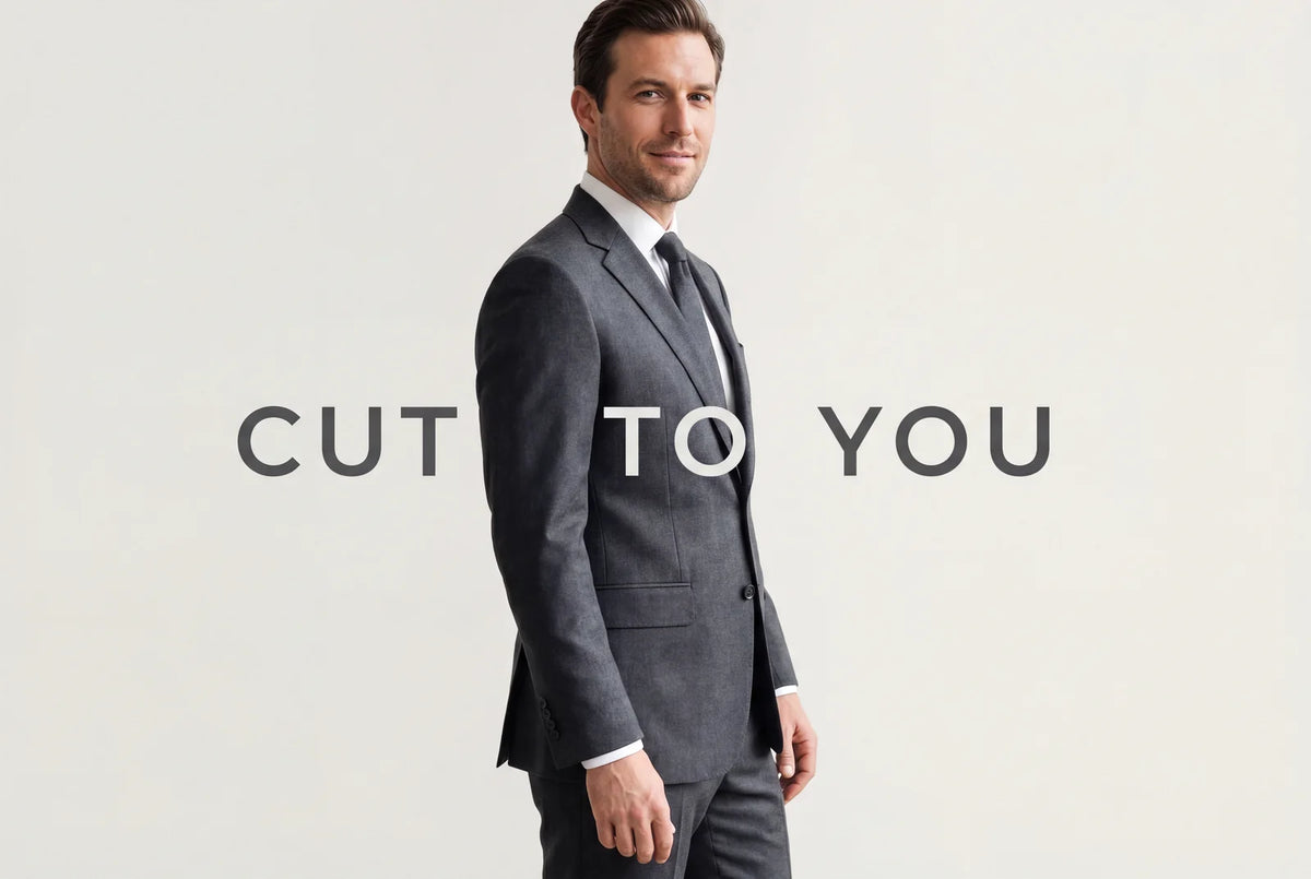 A man in a precisely fitted charcoal suit, cut to the individual body