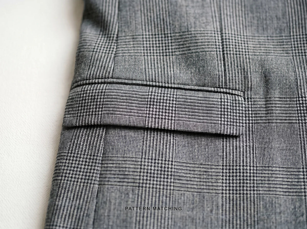 Glen-check suit with the pattern matched across the pocket flap and body seam