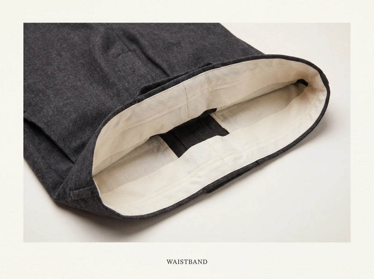Inside of grey wool suit trousers showing a clean curtain-lined waistband interior