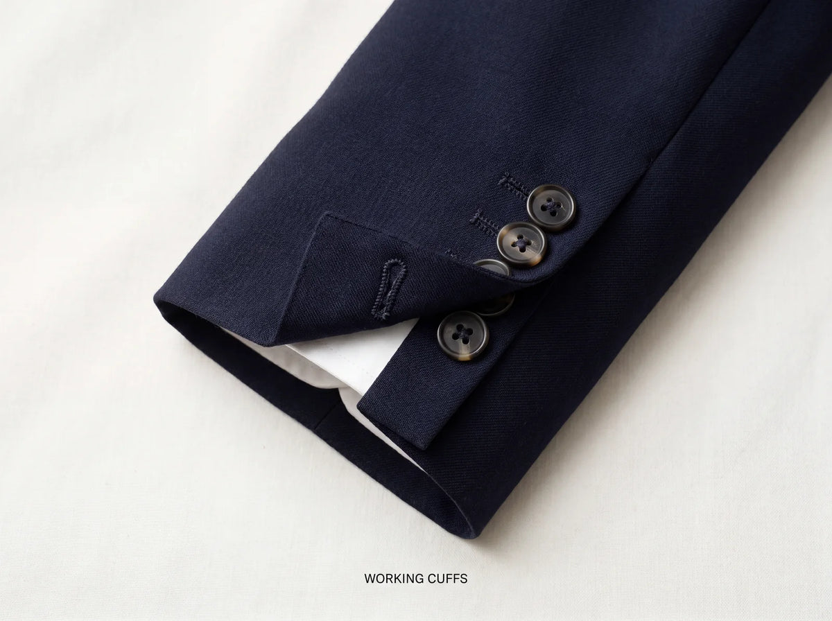 A working surgeon cuff with one buttonhole undone on a navy suit sleeve