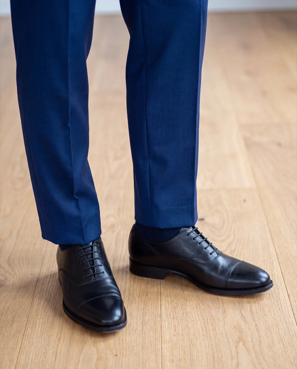 Ask the tailor for a hem that just reaches the top of your shoe, with a small fold or none.