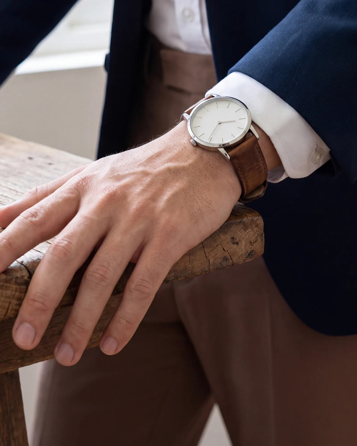 Pick one accent and stop there. A plain watch on a leather strap is enough, without stacked bracelets or a busy pocket square.