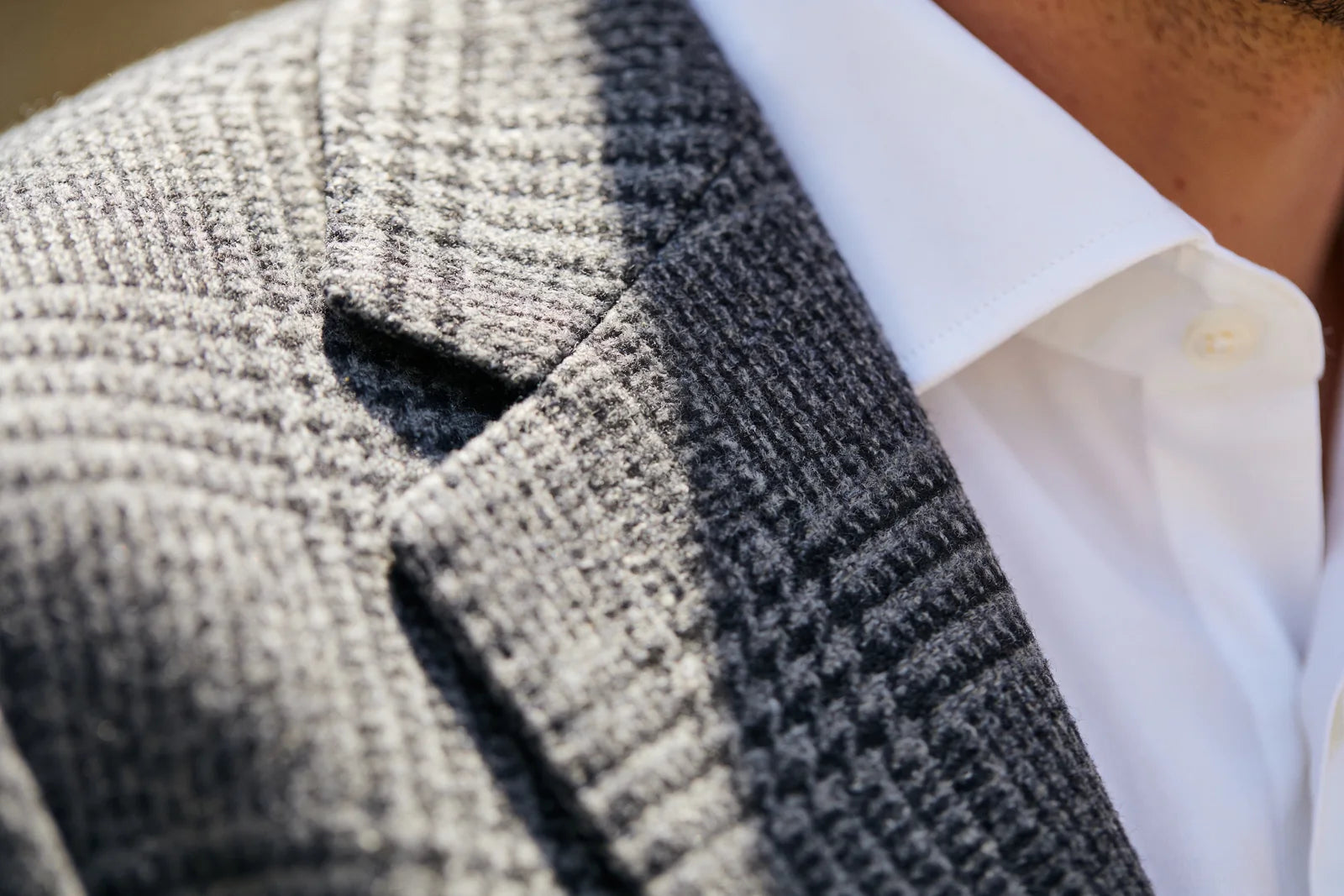 Close detail of a textured wool suit jacket showing the fabric weave