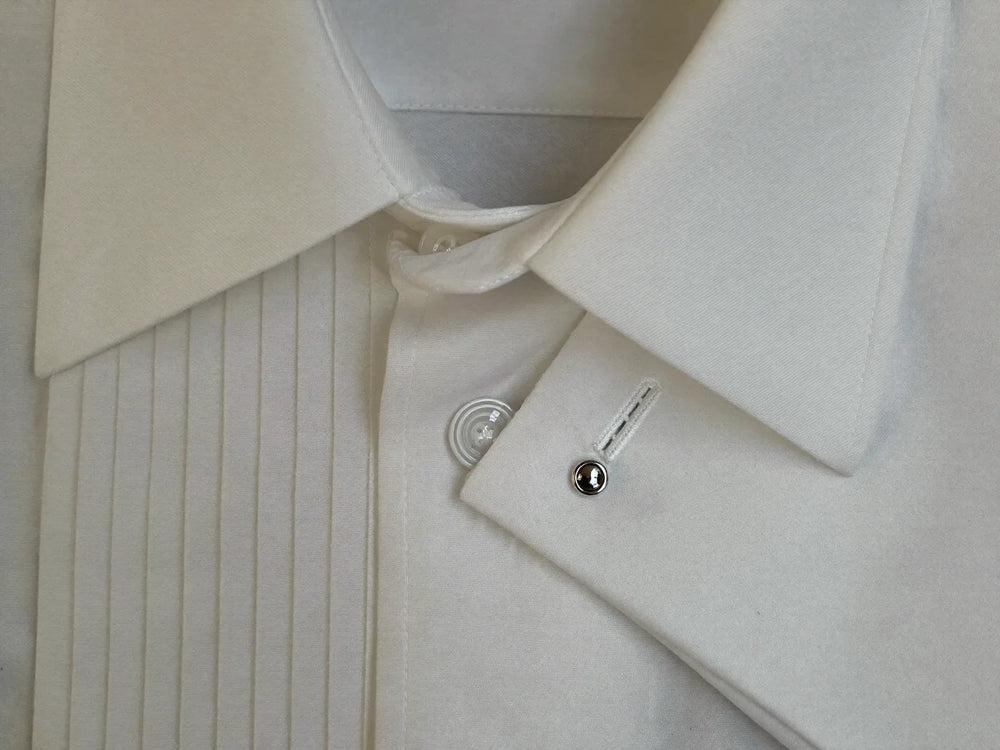 Close-up of a white tuxedo shirt collar, pleated bib front and French cuff with a cufflink